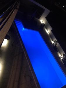 uma piscina azul com luzes num edifício em Villa Ana perfect for families with kids and groups,House with heated Pool em Podstrana