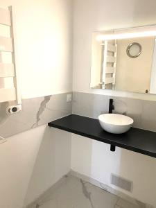 uma casa de banho com um lavatório e um espelho em Proche plage de Royan, vue mer, équipements modernes, confort em Saint-Georges-de-Didonne