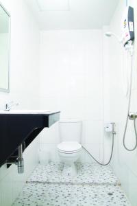 a white bathroom with a toilet and a sink at Krabi Orchid Hometel in Krabi