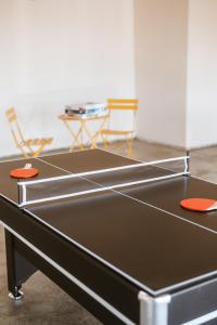 a ping pong table in a room with two chairs at Cassia Tree in Twentynine Palms