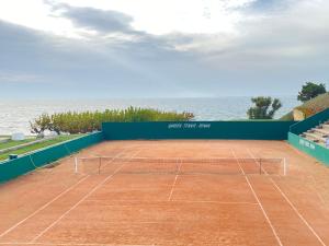 una pista de tenis con el océano en el fondo en Proche plage de Royan, vue mer, équipements modernes, confort, en Saint-Georges-de-Didonne