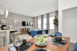 a kitchen and living room with a table and chairs at Casa Azure - New Modern 3 BR, Med Center, NRG, UH in Houston