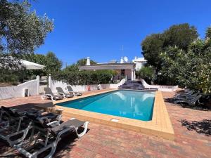 una piscina con sedie e una casa di Beautiful private Villa with pool, Boliqueime, Loulé a Boliqueime