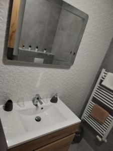 a bathroom with a white sink and a mirror at Studio apartman Implex in Đakovo