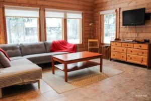 a living room with a couch and a coffee table at Lovely cottage in Koli resort next to a large lake and trails in Kolinkylä