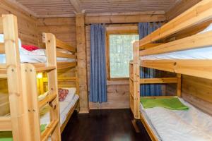 a log cabin with two bunk beds in it at Lovely cottage in Koli resort next to a large lake and trails in Kolinkylä