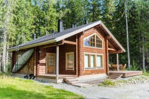 a small wooden cabin in the woods at Lovely cottage in Koli resort next to a large lake and trails in Kolinkylä