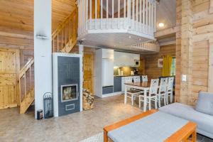 a living room with a fireplace and a kitchen at Lovely cottage in Koli resort next to a large lake and trails in Kolinkylä