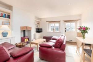 un soggiorno con un divano rosso e un tavolo di Driftwood Cottage pets go free WiFi included a Hunstanton