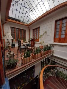 une véranda avec une terrasse dotée d'une table et de chaises dans l'établissement Hotel Casa de la Luz, à Bogotá