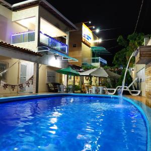 ein Schwimmbad in der Nacht mit einem Springbrunnen in der Unterkunft Pousada Barreirinhas House in Barreirinhas