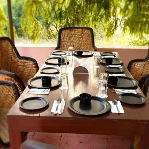 a wooden table with black plates and napkins on it at Namanbagh in Alwar