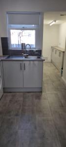 an empty kitchen with a sink and a window at Cheerful 3-bedroom home in Sale - free parking on premises in Sale