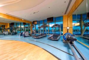 a gym with a swimming pool and exercise equipment at 1 Bed Apartment with Sea View, Pool, Gym & Free Parking in Dubai Marina in Dubai