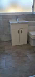 a bathroom with a sink and a toilet at Cheerful 3-bedroom home in Sale - free parking on premises in Sale
