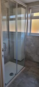 a shower with a glass door in a bathroom at Cheerful 3-bedroom home in Sale - free parking on premises in Sale