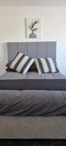 a bed with two pillows on top of it at Cheerful 3-bedroom home in Sale - free parking on premises in Sale