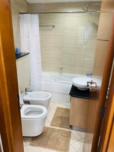 a bathroom with a white toilet and a sink at 1 Bed Apartment with Sea View, Pool, Gym & Free Parking in Dubai Marina in Dubai