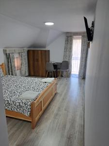 a bedroom with a bed and a table with chairs at Enduro Transalpina in Obarsia-Lotrului