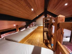 um quarto com 2 beliches e um tecto de madeira em Gite Familiale La Classe em Modave
