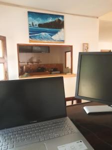 um computador portátil sentado numa secretária com um monitor em Popoyo Surfcamp em Popoyo