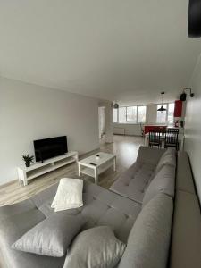 a living room with a large couch and a flat screen tv at Annas ielas apartamenti in Valmiera