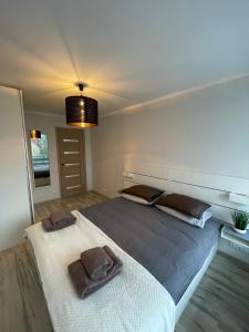 a bedroom with a large bed with two towels on it at Annas ielas apartamenti in Valmiera