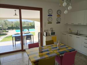 cocina y comedor con mesa y sillas en Rosso di Sera en Alguer