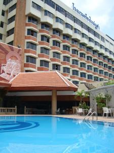 a hotel with a swimming pool in front of a hotel at Chiang Mai Phucome Hotel in Chiang Mai