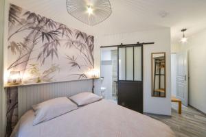 - une chambre avec un grand lit orné d'une fresque murale de palmiers dans l'établissement Appart Bambou rdc - parking gratuit- Netflix, à Bourges