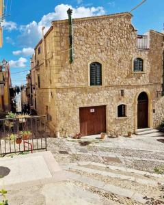 ein altes Steingebäude mit einer Tür und einem Tor in der Unterkunft Casa Al Plumbago in Termini Imerese