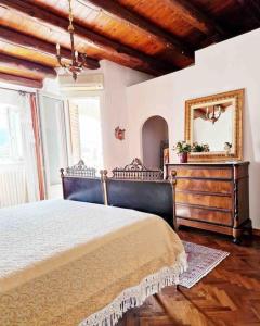 a bedroom with a bed and a mirror and a dresser at Casa Al Plumbago in Termini Imerese