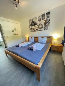 1 dormitorio con 2 camas con sábanas azules y carteles en Ferienwohnung & Apartment Am Steinbrunnen, en Brauneberg