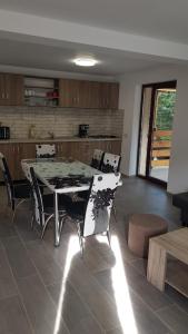 a dining room with a table and chairs in a kitchen at Enduro Transalpina in Obarsia-Lotrului