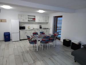 a kitchen with a table and chairs and a refrigerator at Enduro Transalpina in Obarsia-Lotrului