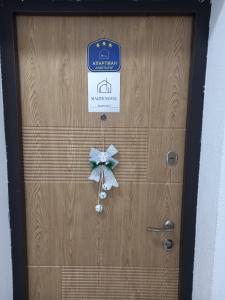 d'une porte en bois munie d'un signe et d'une étrave. dans l'établissement Apartmani Martenovic 1, à Vrnjačka Banja