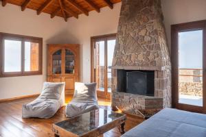 a living room with a stone fireplace and a couch at Stone Sunset Villa in Sfendoúrion