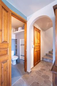 a bathroom with a toilet and a hallway with a door at Stone Sunset Villa in Sfendoúrion