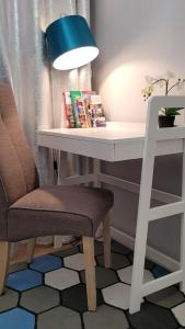 a white desk with a chair and a blue lamp at Lovely flat in heart of Wroclaw in Wrocław