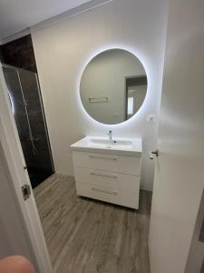 a bathroom with a white sink and a mirror at Apartamento en la playa. Free Parking. Free WiFi in L'Escala +9 photos