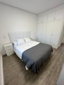 a white bedroom with a large bed and white cabinets at Apartamento en la playa. Free Parking. Free WiFi in L'Escala