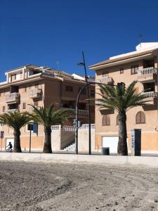 a building with palm trees in front of a building at Apartamento Costa Calida in San Pedro del Pinatar