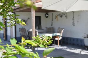 een patio met een tafel en stoelen en een parasol bij VELOCIPEDE OUDENAARDE vakantieverblijf 6 pers ADULTS ONLY in Oudenaarde