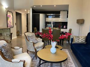 a living room with a blue couch and a table with red flowers at Luxury 2-floor Flat (95 sqm) near Hotel Martinez in Cannes