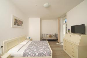 a bedroom with a bed and a tv on a dresser at Hotel Ristorante Lepanto in Salò