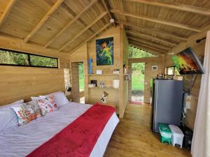 a bedroom with a bed in a wooden house at Caralsol Glamping in Rionegro