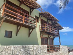d'un bâtiment avec des balcons et l'océan en arrière-plan. dans l'établissement Beach Suites Villa Drisana, à Barra de Camaratuba