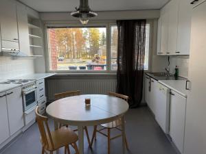 cocina con mesa, sillas y ventana en Iso huoneisto 4, en Ylivieska