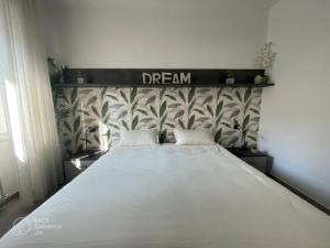 a bedroom with a large bed with a dream sign above it at R39 Modern Apartment with Private Parking in Milan