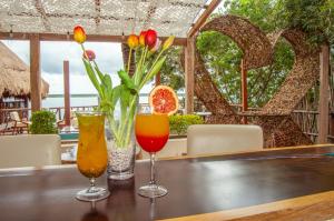 un tavolo con due cocktail e dei fiori sopra di Xcabal Hotel boutique a Bacalar